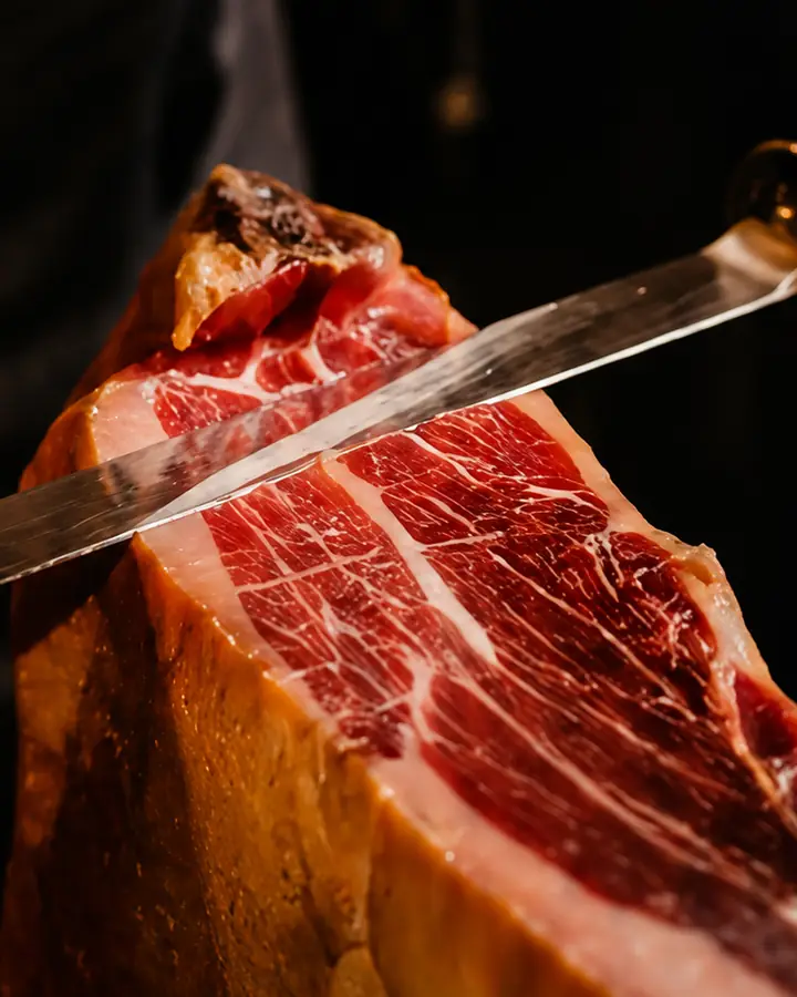 Cortador loncheando a cuchillo una pieza de jamón ibérico